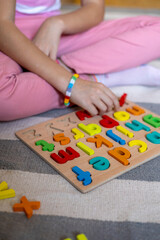 Child learns to put words out of letters. English alphabet. Eco friendly toy