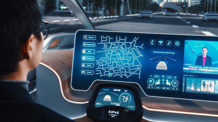 Futuristic Concept: Stylish Businessman Using Navigation App on an Augmented Reality Dashboard with Financial News Broadcast while Sitting in an Autonomous Self-Driving Zero-Emissions Electric Car. 