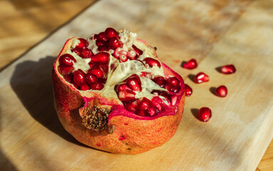 Half a pomegranate placed on a wooden board 