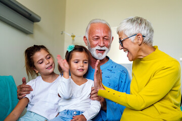 Family visiting senior male patient in hospital bed. Healthcare, support, family concept