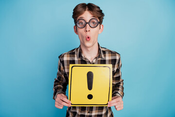 Photo of young man hold paper card sign attention new driver warning symbol isolated over blue color background