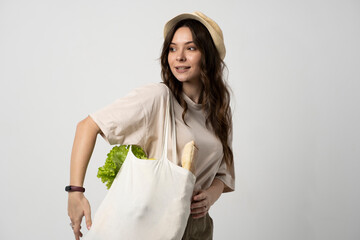 Woman holding textile grocery bag with vegetables. Zero waste concept. Package-free food shopping....