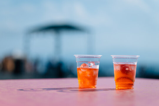 Fresh orange cocktails in plastic cups on the table during a beach party in Lake Sevan, Armenia