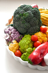 Fresh vegetables for vegan cuisine carrots, corn, cabbage, peppers, broccoli, tomatoes on a white background, copy space