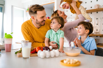 Happy family preparing healthy food together in kitchen