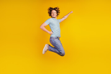 Full-body profile side photo of young cheerful man happy positive smile jump superman fly protect isolated on shine yellow background