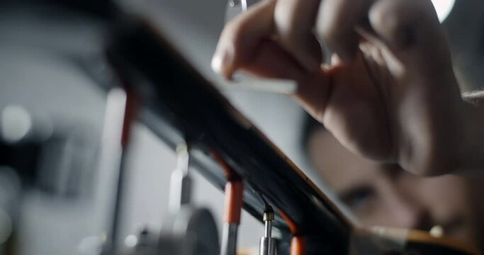 Luthier checks the fretboard radius of the electric guitar after sanding, repair of the musical instruments at the guitar workshop, 4k 60p 10 bit