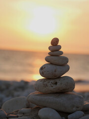 stack of pebbles facing the sunset over the ocean