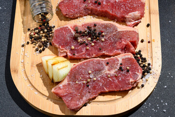 raw meat on a wooden board with seasonings coarse salt and pepper onion igredientes for preparing the churrasco, Brazilian barbecue