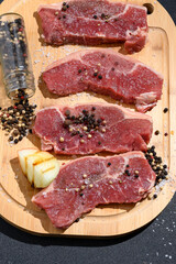 raw meat on a wooden board with seasonings coarse salt and pepper onion igredientes for preparing the churrasco, Brazilian barbecue