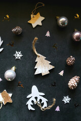 Various Christmas ornaments and colorful sequins on dark background. Flat lay.
