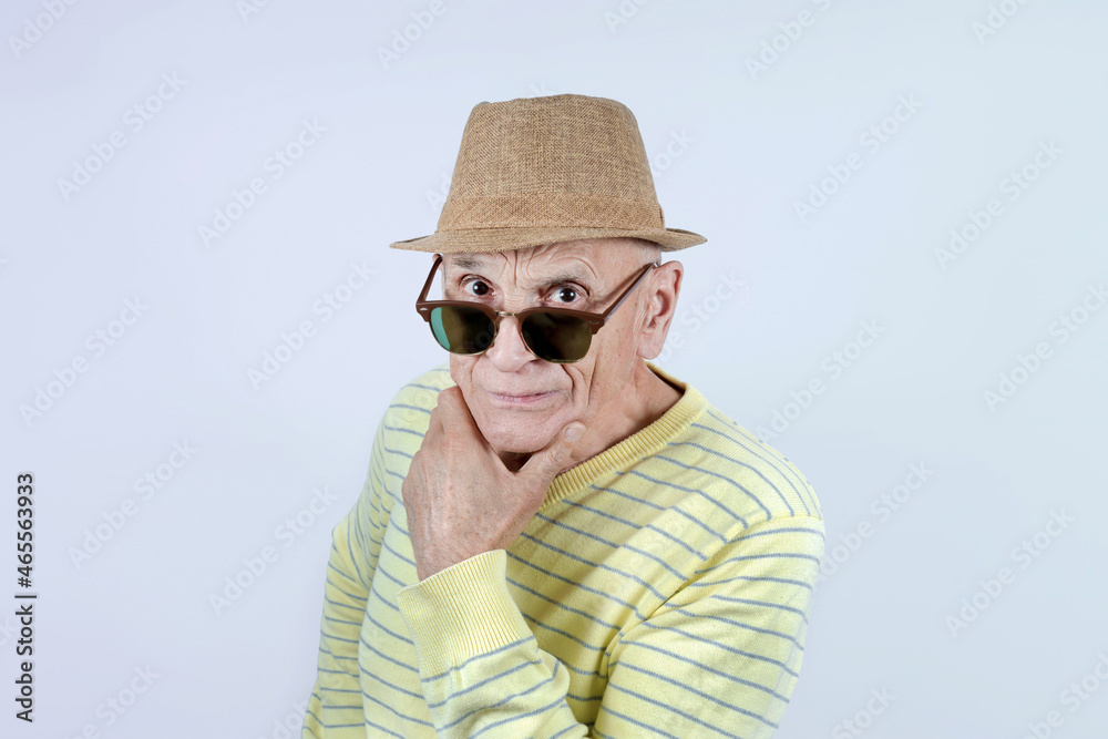 Wall mural Aged caucasian man wearing hat and black eyeglasses