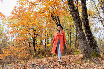 Young girl with blond hair walks in the autumn forest. Wellness concept.
