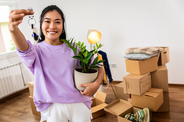 Portrait of young woman holding keys of her new home.