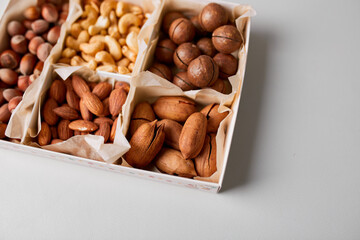 Assorted nuts in box nuts: pecan, almond, macadamia, brazil, cashew, hazelnut, Rich in minerals and protein. Healthy nutrition, high in zinc, magnesium and vitamins, online ordering, shoping concept.