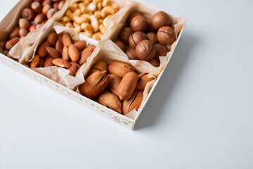 Assorted nuts in box nuts: pecan, almond, macadamia, brazil, cashew, hazelnut, Rich in minerals and protein. Healthy nutrition, high in zinc, magnesium and vitamins, online ordering, shoping concept.