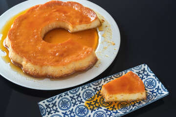 Pudding, delicious Brazilian condensed milk dessert, cut into pieces, on a plate.