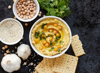 Hummus - chickpea traditional jewish and lebanese cuisine meal on black background, flat lay, from above overhead top view, closeup, houmous is a vegan healthy legume food