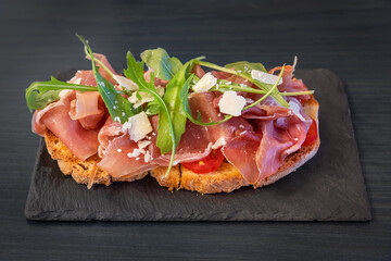 Sandwich with ham, cheese, tomato and salad. On the stone plate. Close up