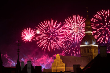 Riga cathedral from the 13th century with fireworks in the background at night. Latvia.