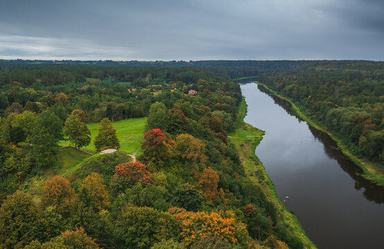 Punia mound in Lithuania with green grass and autumn trees background, road to mountain