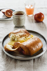 Breakfast with Twisted Bun with cheese and jam, hot chocolate, juice and oranges. Red-Jam and Cheese Danish. Selective focus