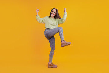 Fototapeta na wymiar Full length photo of young cheerful girl rejoice victory fists hands sale isolated on yellow color background