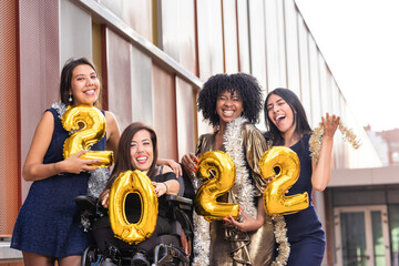 2022 New Year Eve Party multiethnic group with disabled wheelchair friend. healthcare insurance