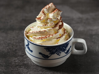 Taza de café con nata y chocolate en polvo