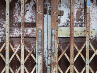 Steel door handles of the old sliding door on wooden door background.
