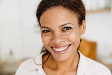 Naklejka na ściany i meble Young black woman smiling and looking at camera