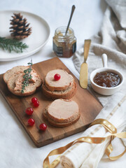 Selective focus of tradtional French foie gras and toaster bread on a wooden plate with Christmas decoration aside with onion marmalade for a festive celebrate. - obrazy, fototapety, plakaty