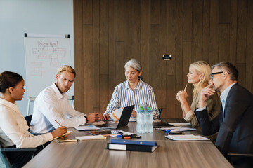 Multiracial men and women discussing project during meeting