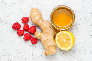 Ginger root with honey jar, lemon and raspberries