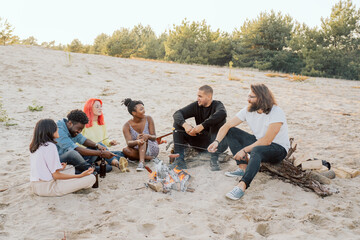 Socializing students get to know each other on a campfire, different skin colors, nationalities,...