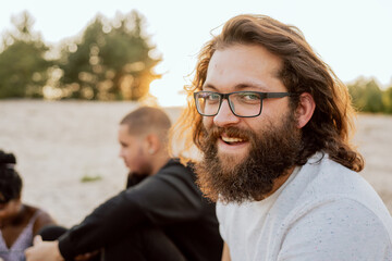 Portrait of a man with glasses, beard and long hair, the guy is wearing a comfortable t-shirt,...