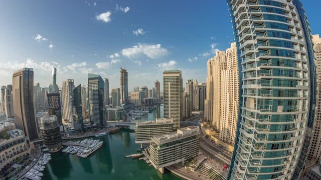 Panoramic aerial view to Dubai marina skyscrapers around canal with floating boats timelapse