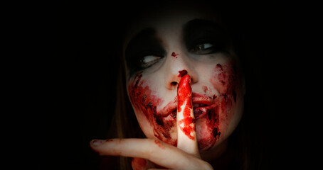 Scary girl in the image of a zombie.
Halloween theme portrait of crazy girl with bloody face. Zombie theme, black background, isolated, killer. Banner, copy of the space.  - obrazy, fototapety, plakaty