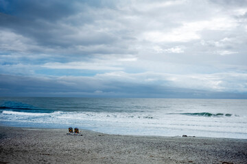 two empty chairs on beach in the morning