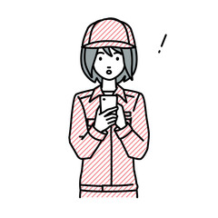 立ってスマートフォンを操作して何かに気づいて驚いた作業員の女性