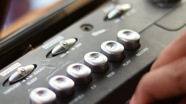  Close Up hand with mustache and mullet from the 70s 80s 90 listens to his music using a portable walkman cassette player. Vintage concept.