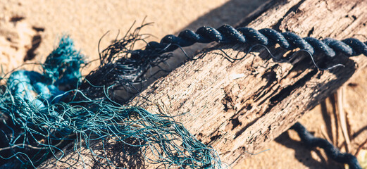 E Close up black blue old fishing twisted cotton sea rope jumble detail on ground. Concept mix maze...