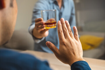 person deny alcohol drink from his friend