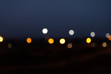 Abstract flashes of multicolored on a dark background, bokeh from the lights. White, red, yellow. Blurred background.