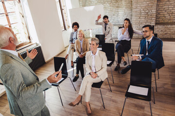 Business people attending seminar in modern office