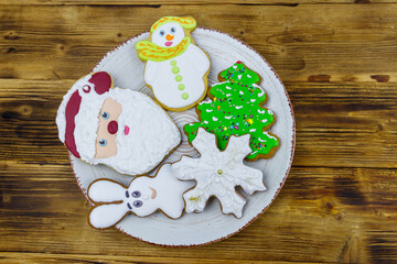 Christmas gingerbread cookies in a plate on a wooden table. Top view