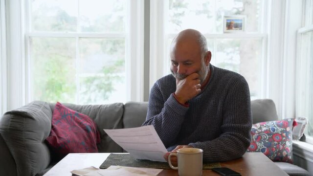 A mature man struggling with home finances and bills mounting up.