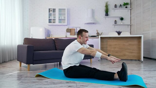 Strong man on quarantine working out in home. Young athletic healthy male training indoors.