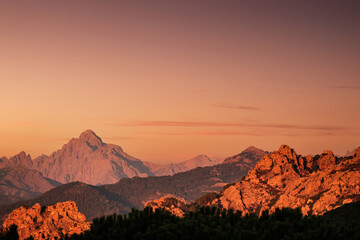 Naklejka premium Evening sun lights up the red rocks and the peak of Paglia Orba mountain in Corsica