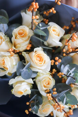 yellow roses with eucalyptus and berries